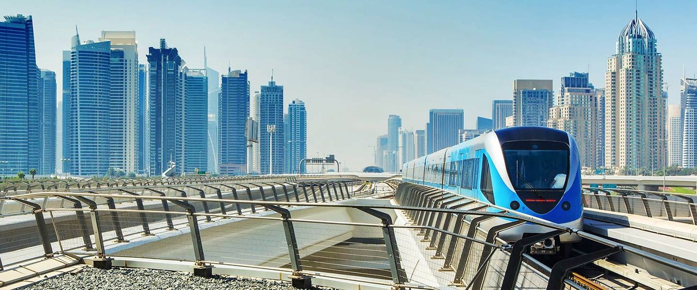 An elevated monorail train glides through a modern city skyline