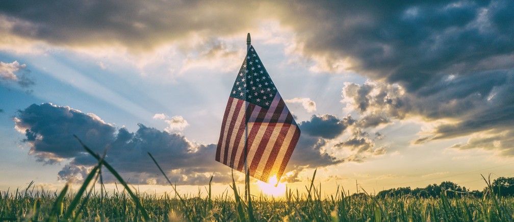 US flag  in the morning light on a grassy field