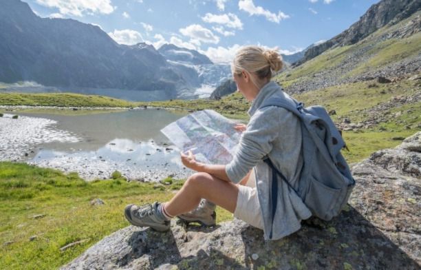 A lady looking at a map as she prepares to make a hike across the grasslands