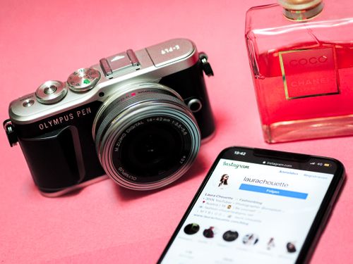 A phone, a camera, and a bottle of perfume