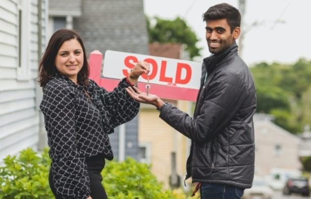Woman real estate agent handing house keys to her client