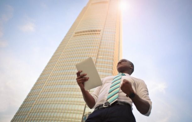 A professional man standing in front ogront of a high rise building