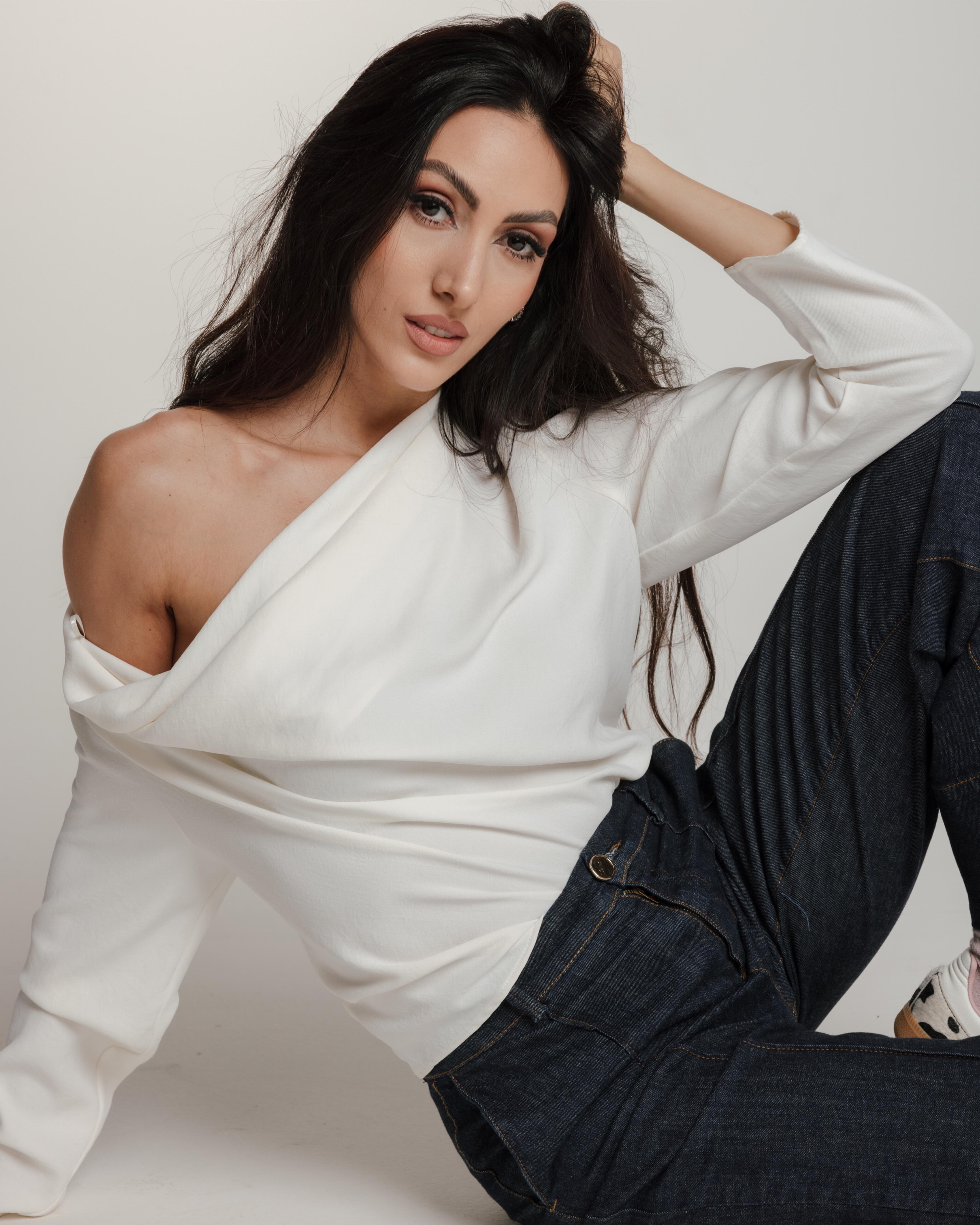 Gala Isidora sedi, ruka u kosi, u beloj bluzi