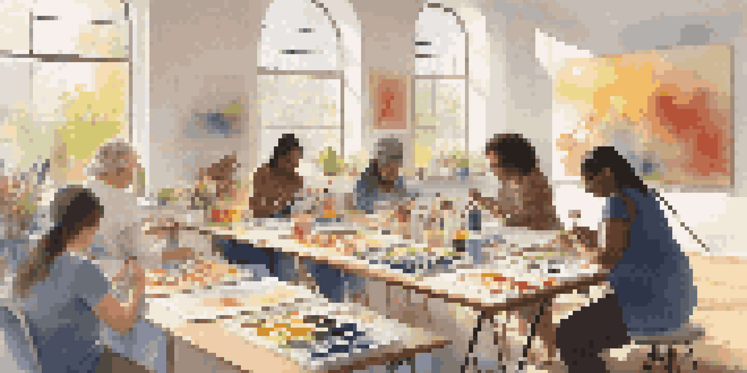 A diverse group of individuals participating in an art therapy session in a bright room with colorful artwork and natural light.