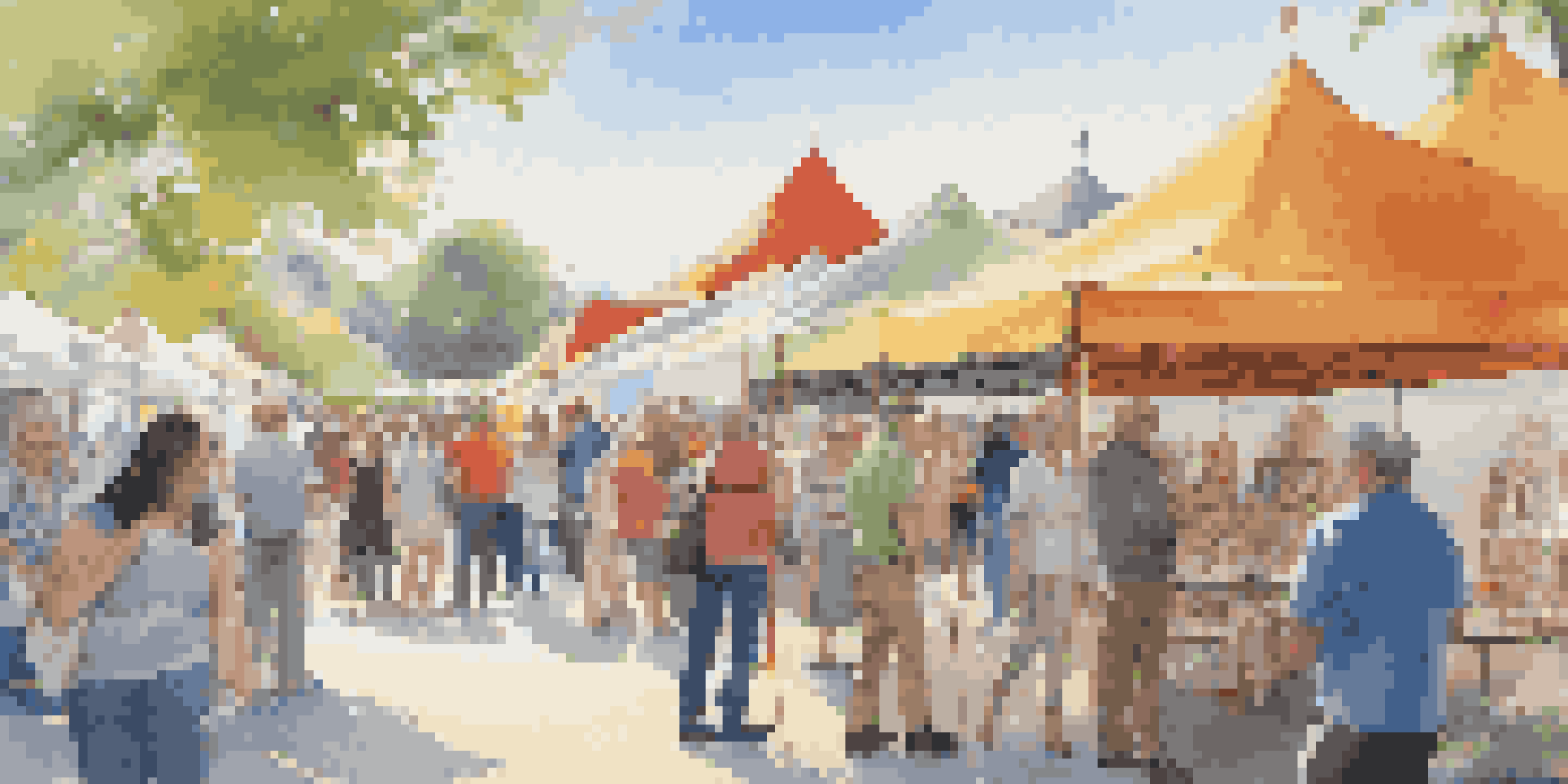 An outdoor art fair with colorful tents and people discussing artworks under a sunny sky.