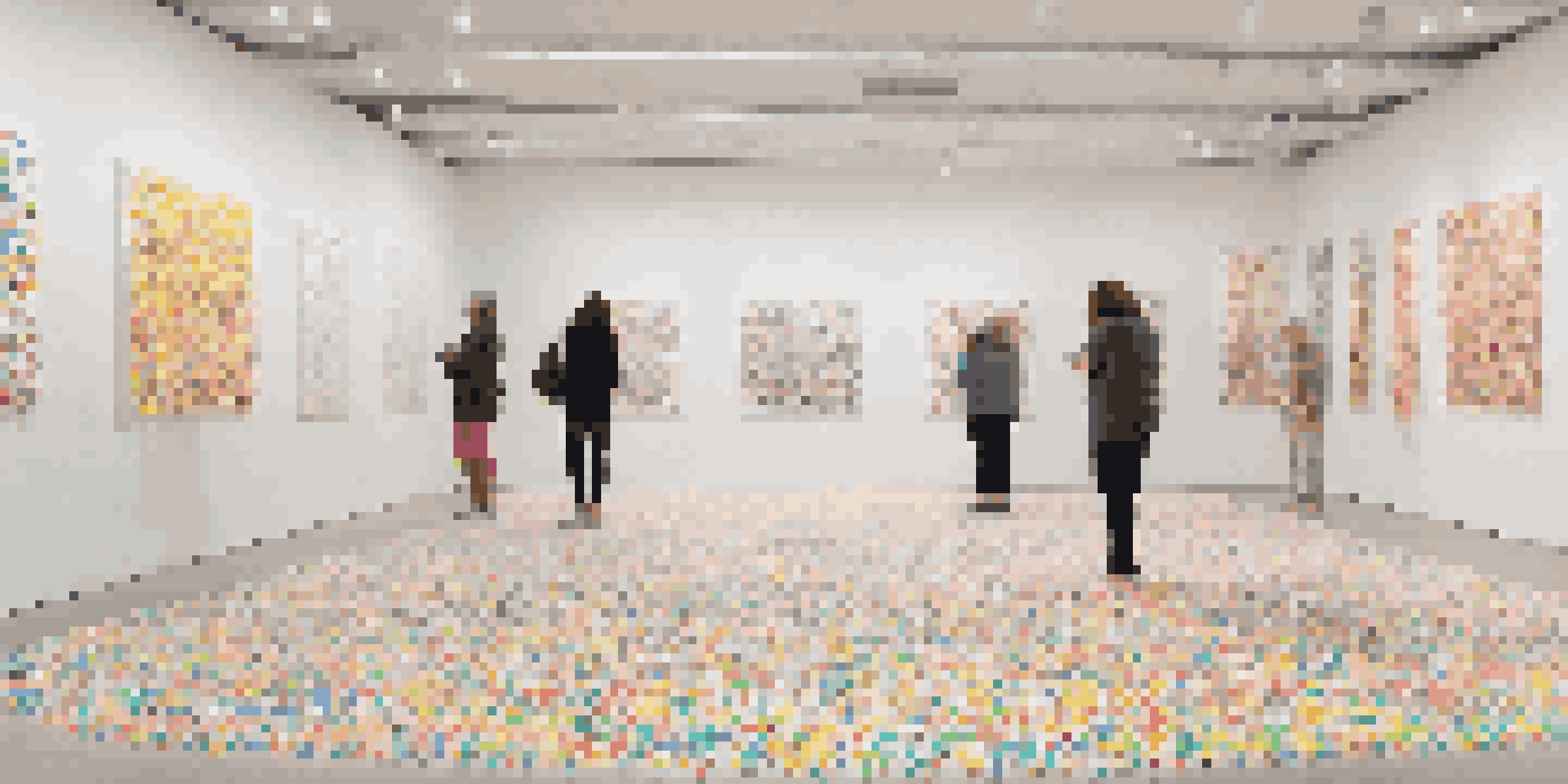 A bright and colorful art installation where a white room is covered in various colored dot stickers, inviting participation and creativity.