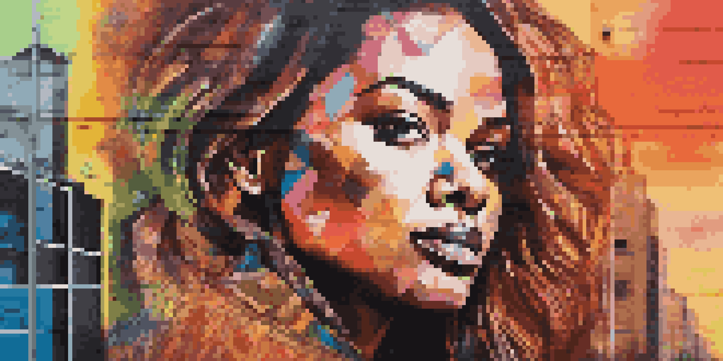 A colorful mural of a celebrity with abstract patterns on a city wall during sunset.