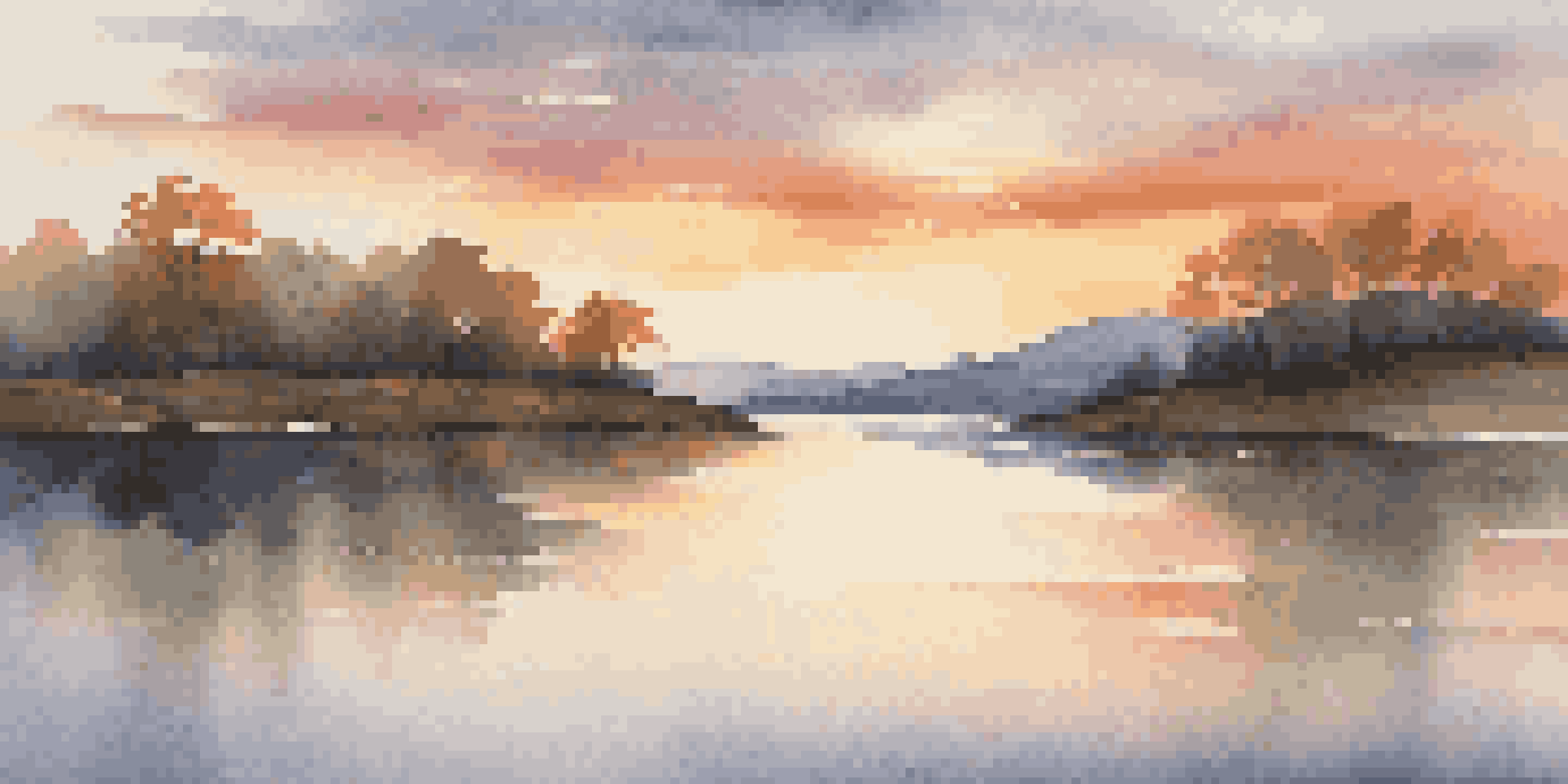 A tranquil lake at sunset reflecting colorful hues with gentle hills in the background and soft waves on the water.