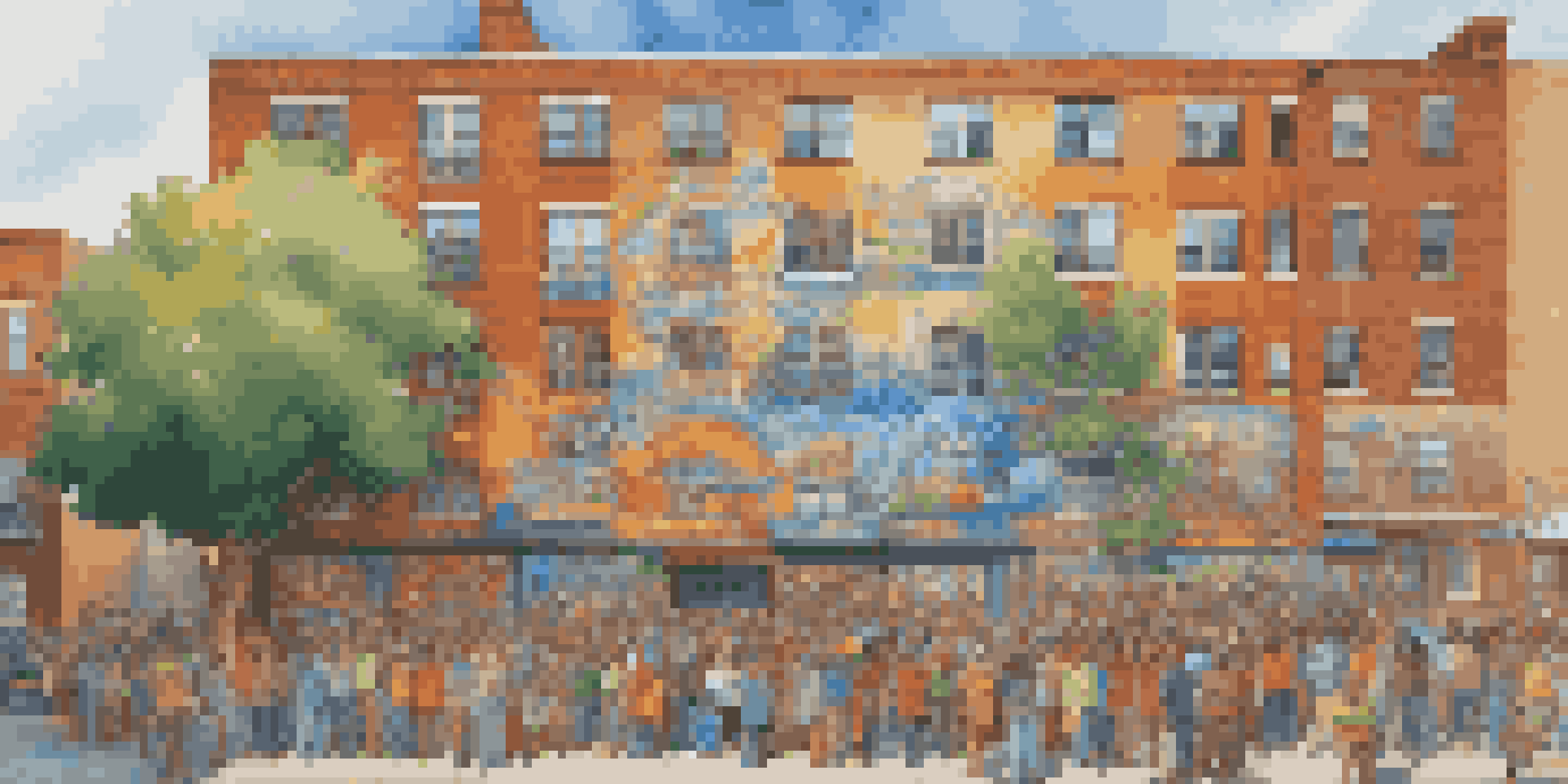 A colorful mural on a brick wall showcasing local heroes and cultural symbols, with people admiring it under the sunlight.