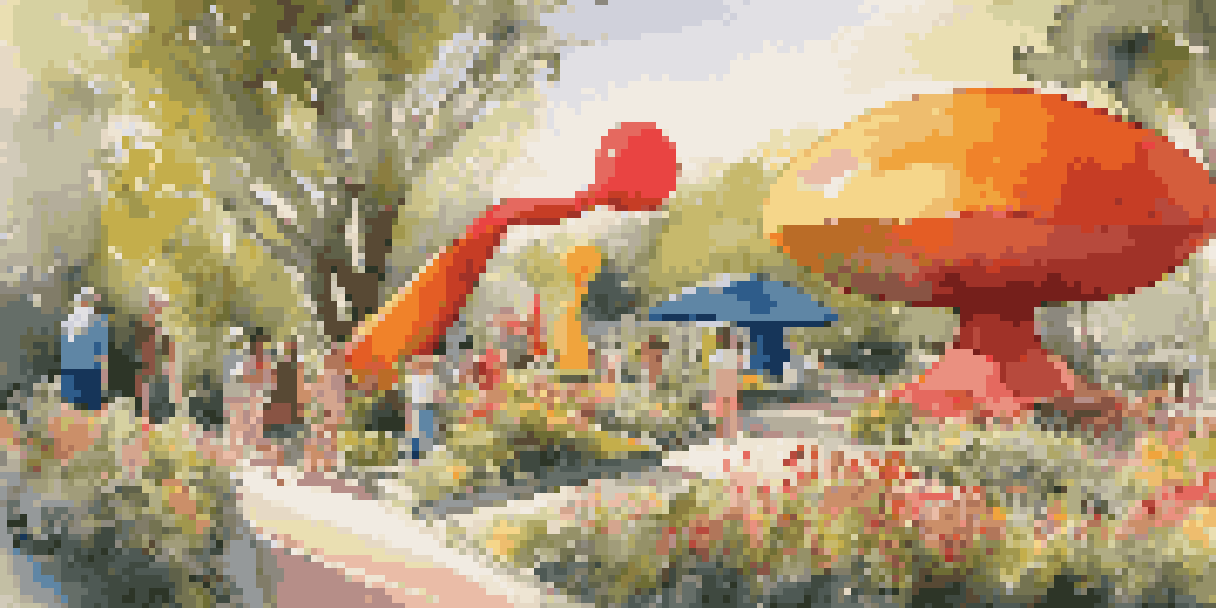 A colorful outdoor art installation with oversized sculptures of everyday objects amidst greenery and flowers, illuminated by warm sunlight.
