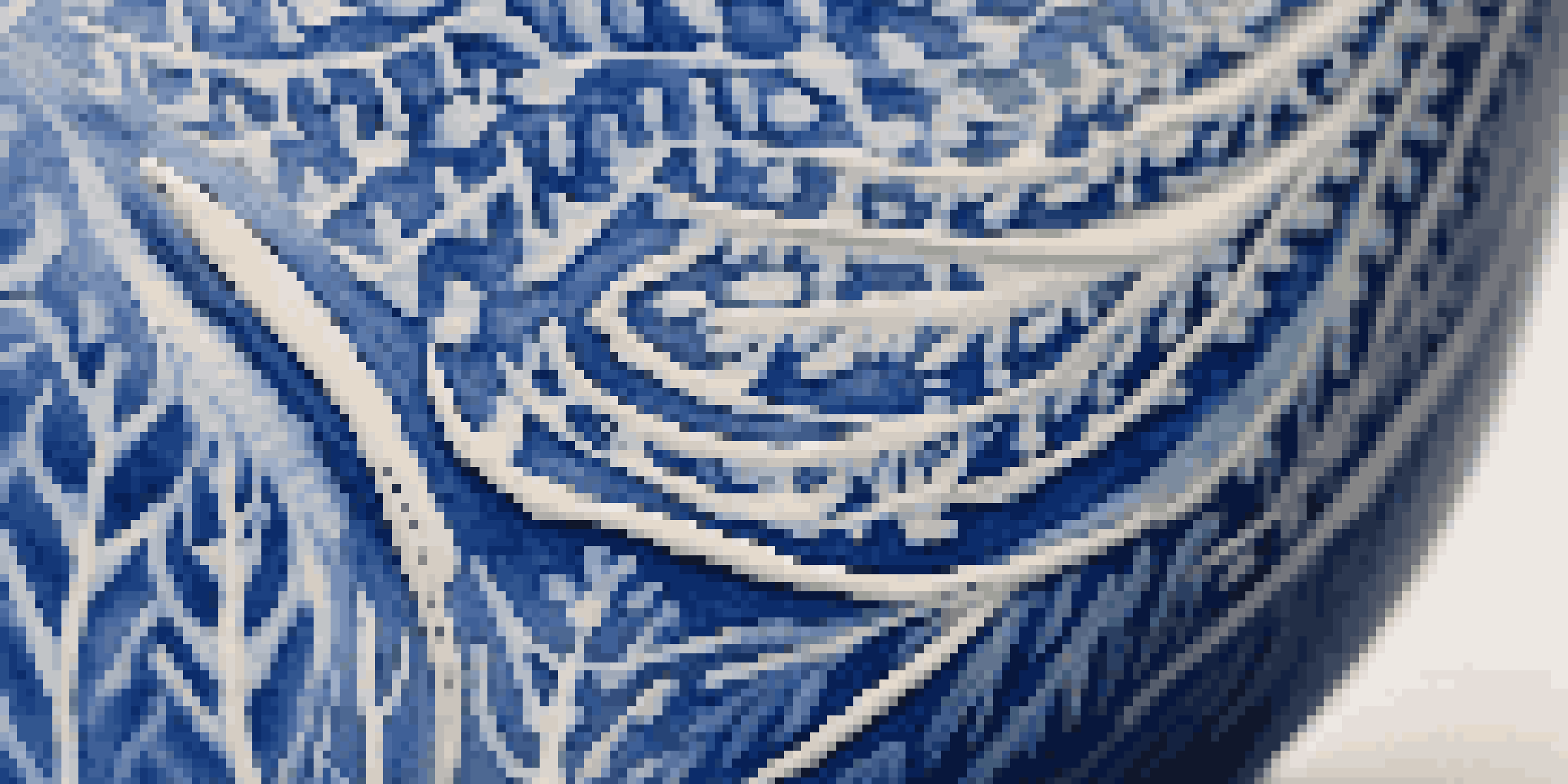 A detailed close-up of a pottery piece featuring leaf patterns created using the sgraffito technique, with contrasting colors of blue and white.