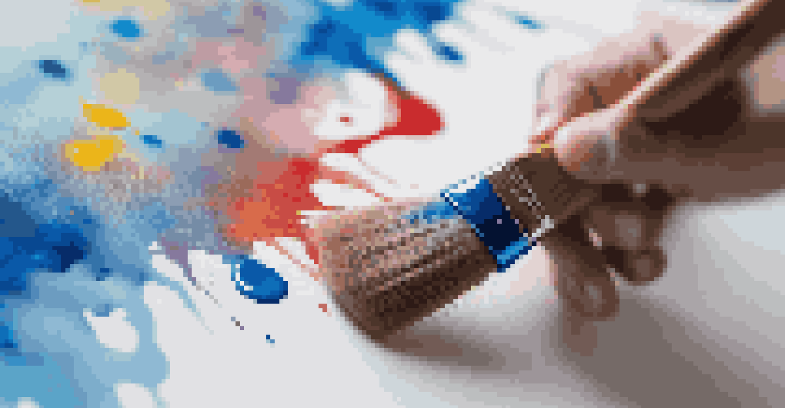 A close-up of a hand holding a paintbrush over a canvas, with bright blue paint and colorful splatters visible.