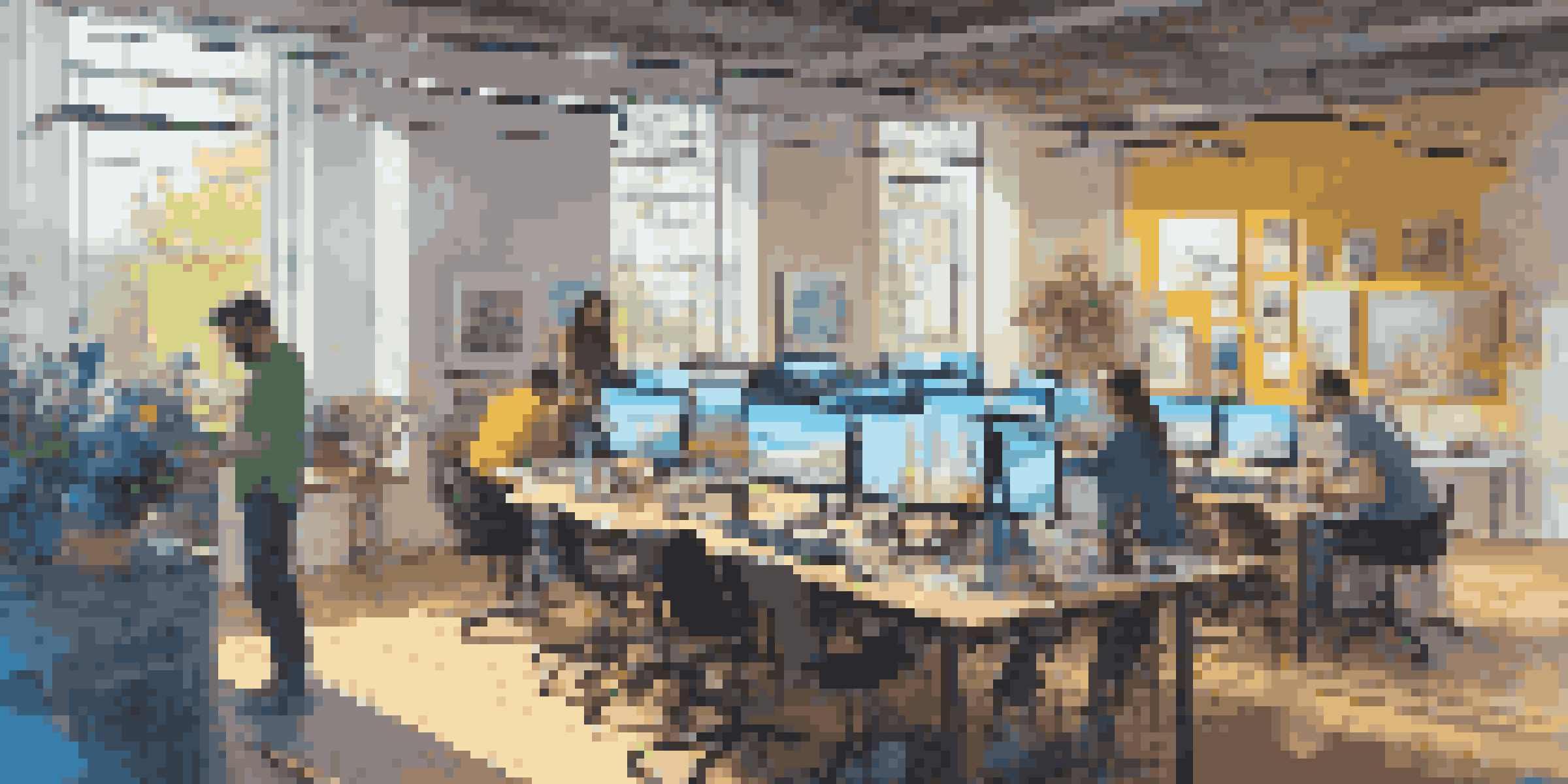 A colorful digital art studio with artists collaborating, natural light, and digital screens.