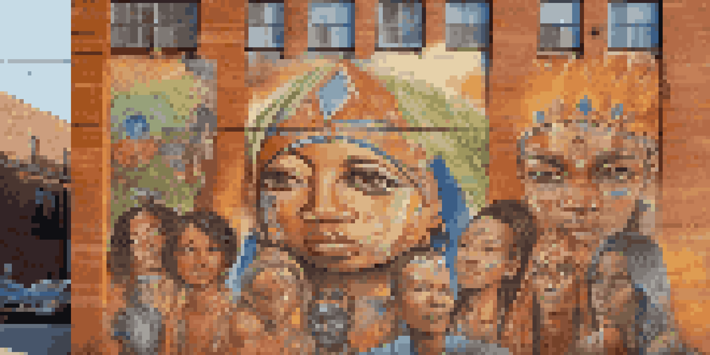 A colorful mural depicting diverse faces and cultural symbols on a brick wall, illuminated by sunlight.