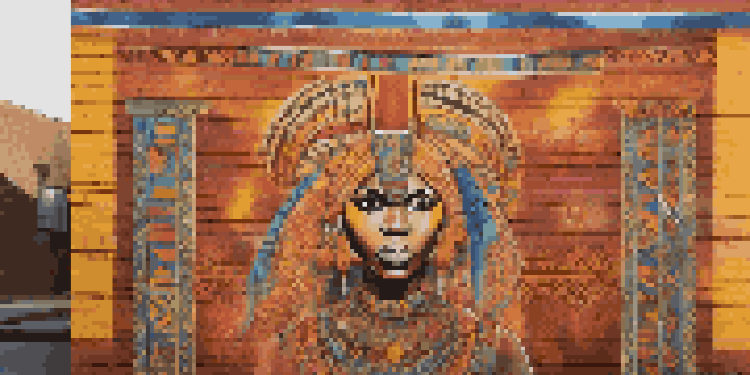 A colorful street mural that blends traditional African designs with modern Western art, illuminated by sunlight on a brick wall.