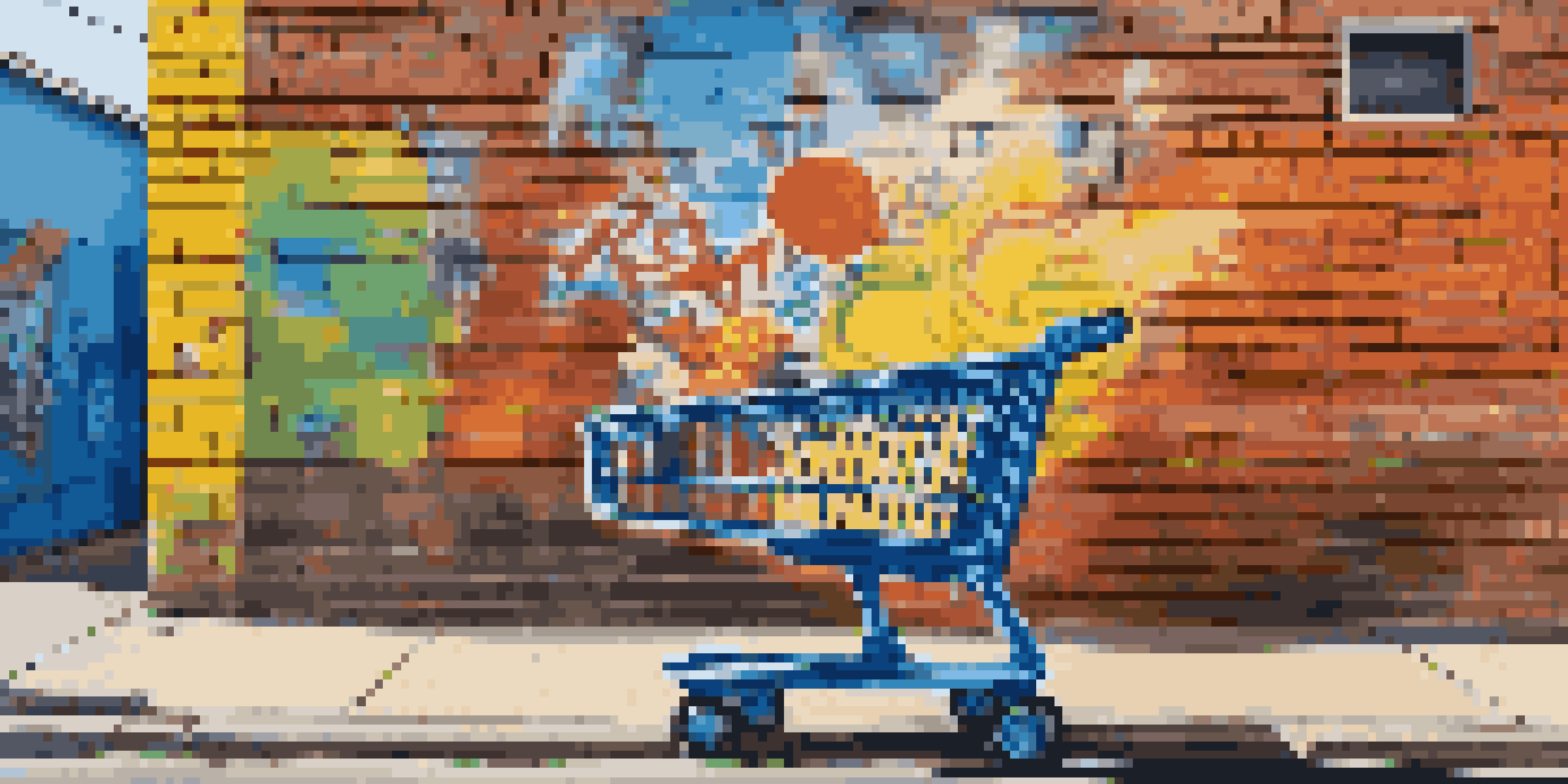 A large mural of a sad-faced shopping cart painted on a brick wall, surrounded by colorful graffiti, emphasizing themes of consumerism.
