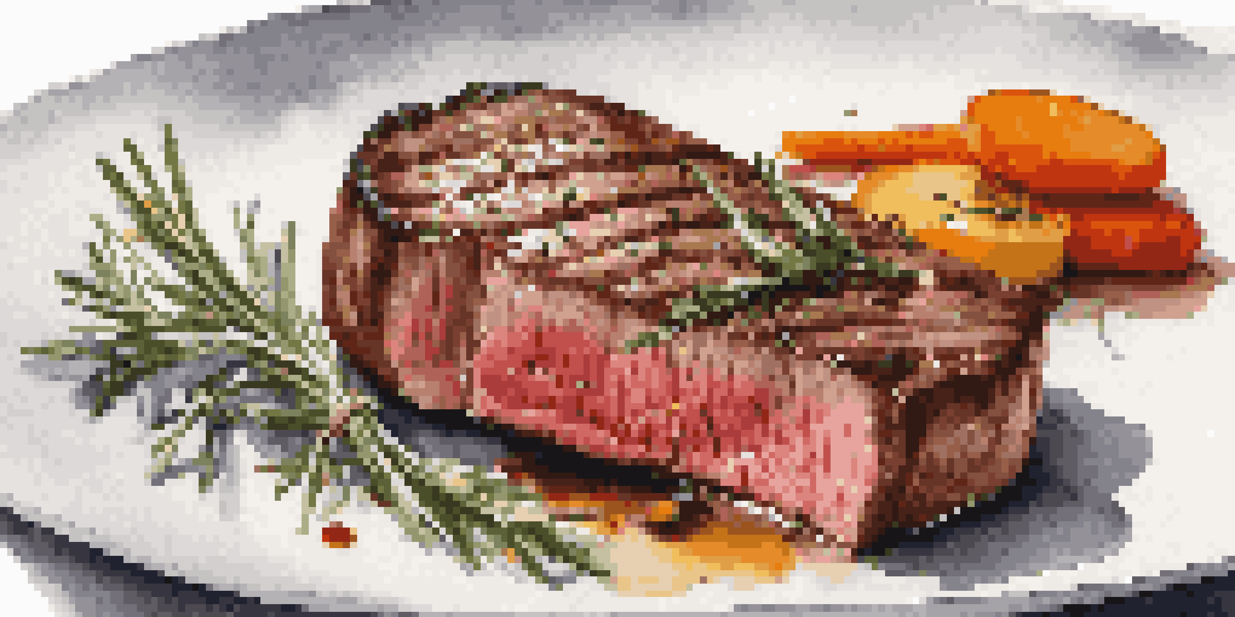 A seared steak on a white plate with a sprig of rosemary and colorful vegetables, showcasing a minimalist presentation.