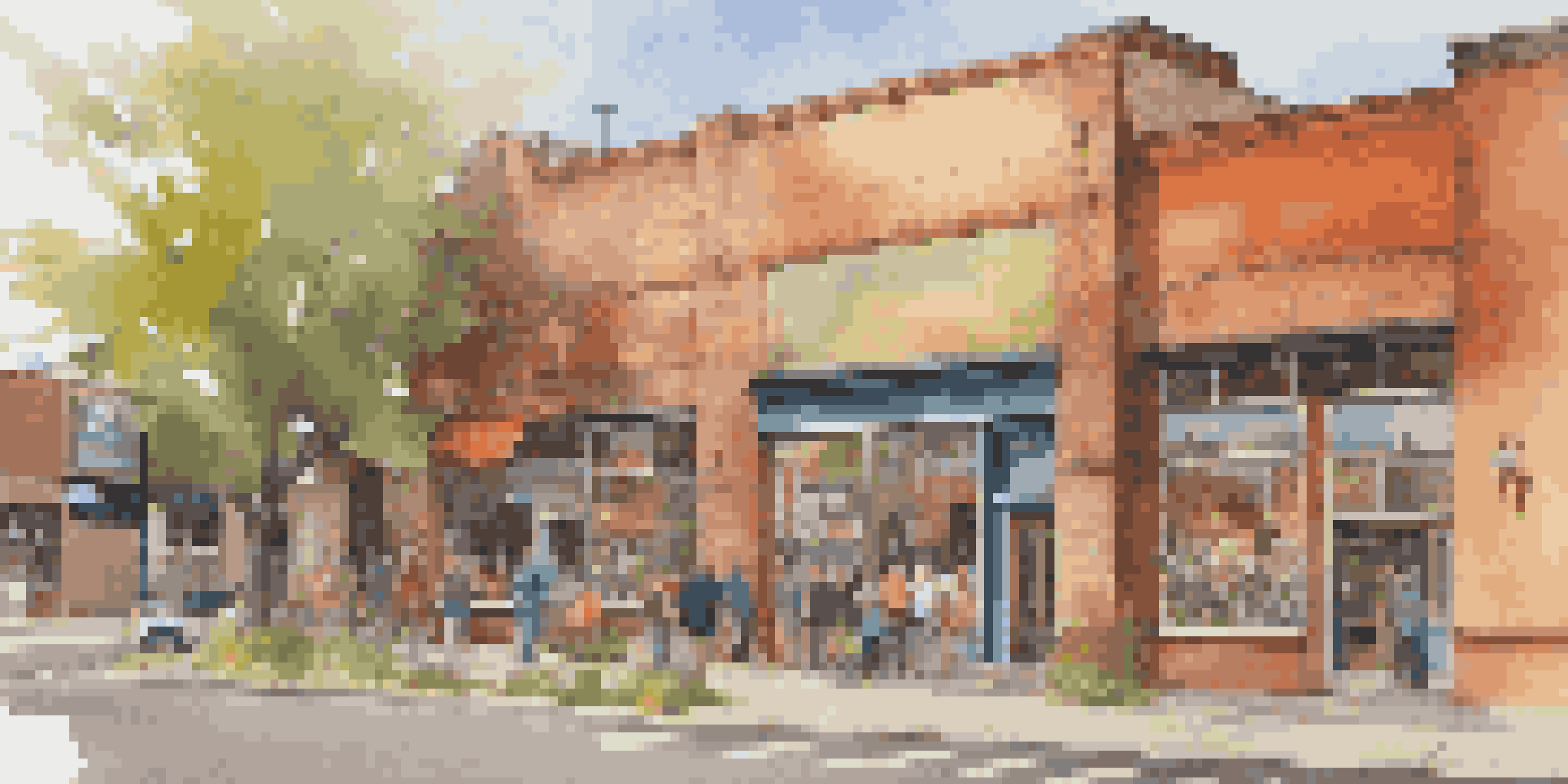 A colorful suburban art gallery with murals and large windows, showcasing local art and visitors in discussion.