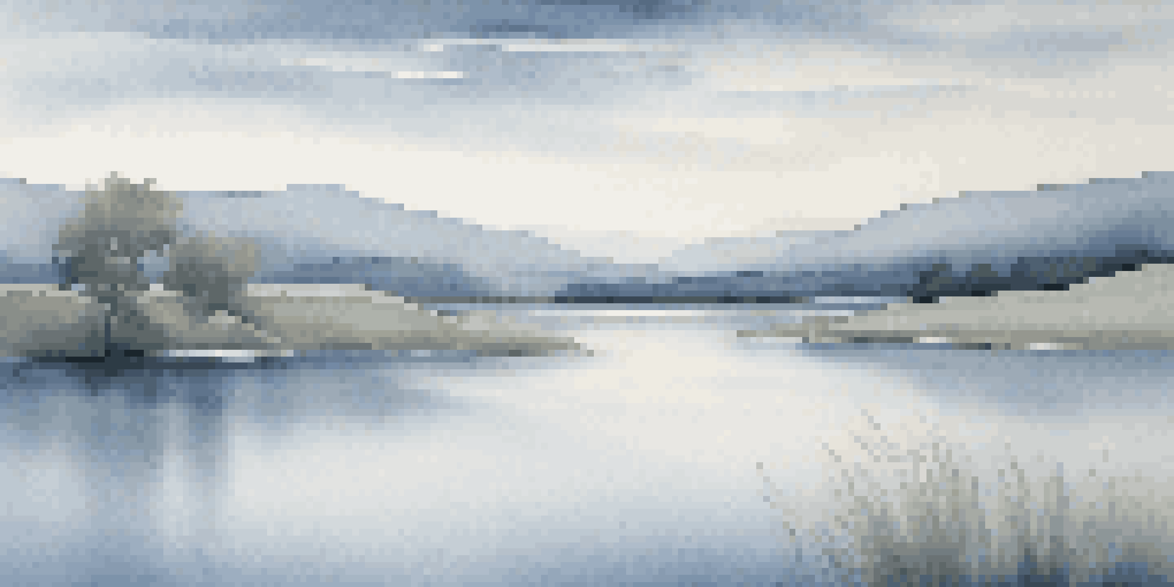 A peaceful landscape in different shades of blue, featuring rolling hills and a lake reflecting the sky.