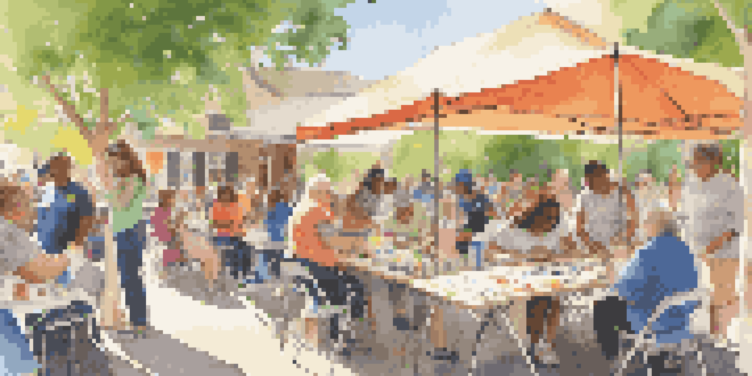 A community event at a museum with diverse people of all ages engaging in art activities outdoors under bright sunlight.