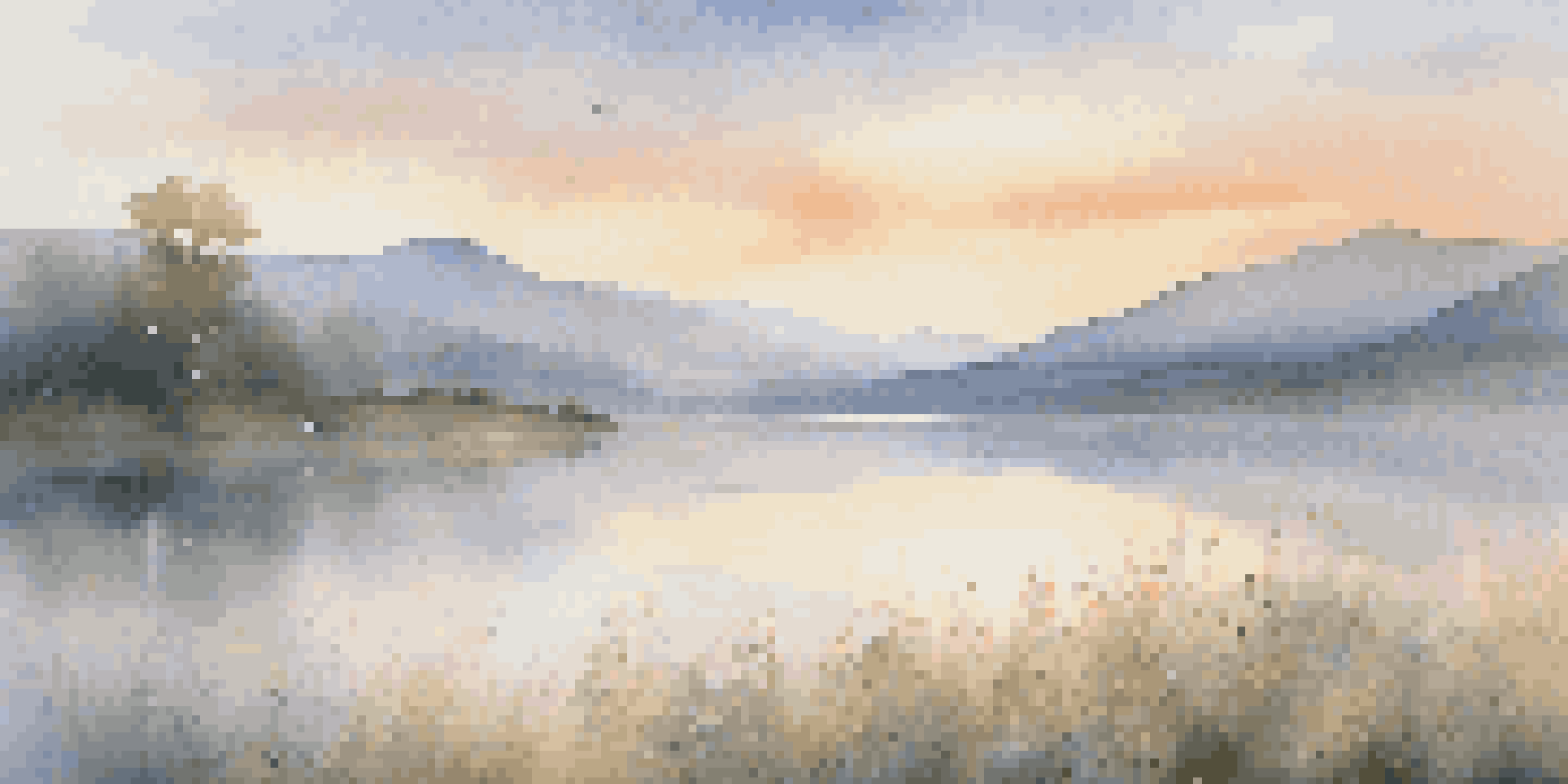 A tranquil lake at dawn with wildflowers in the foreground and misty mountains in the background.