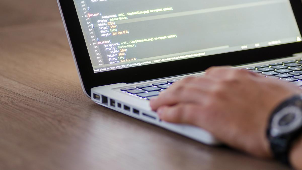 A person writing code on a laptop