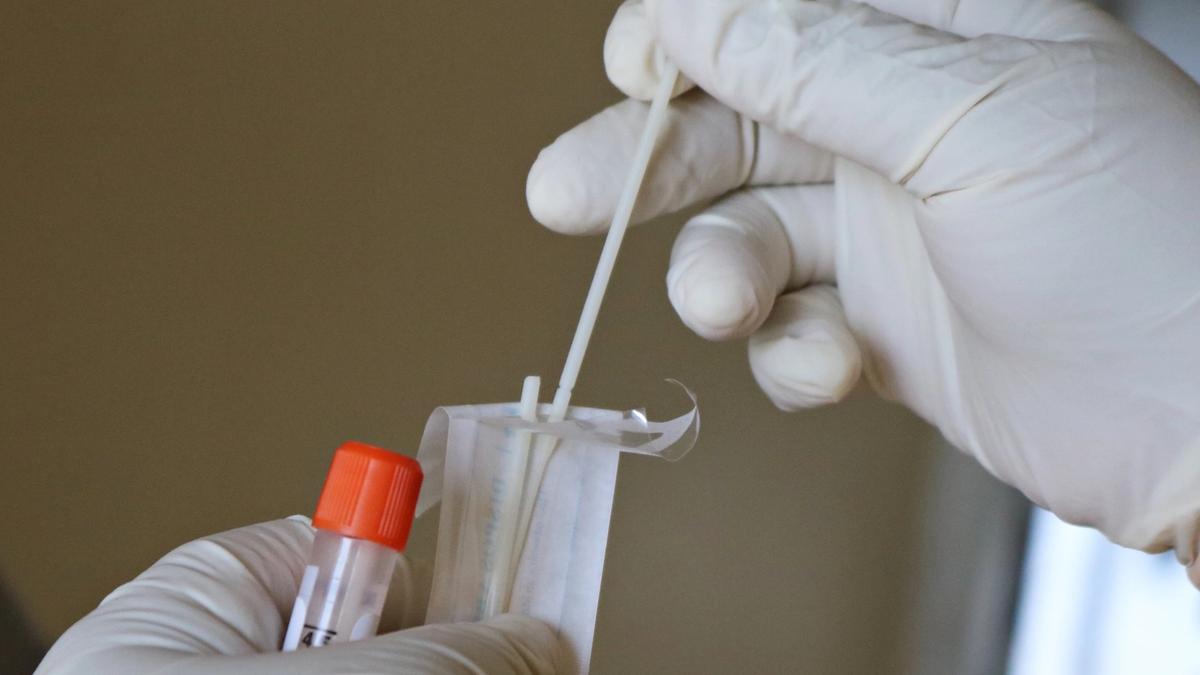 A nasal swab testing kit help by a medical professional
