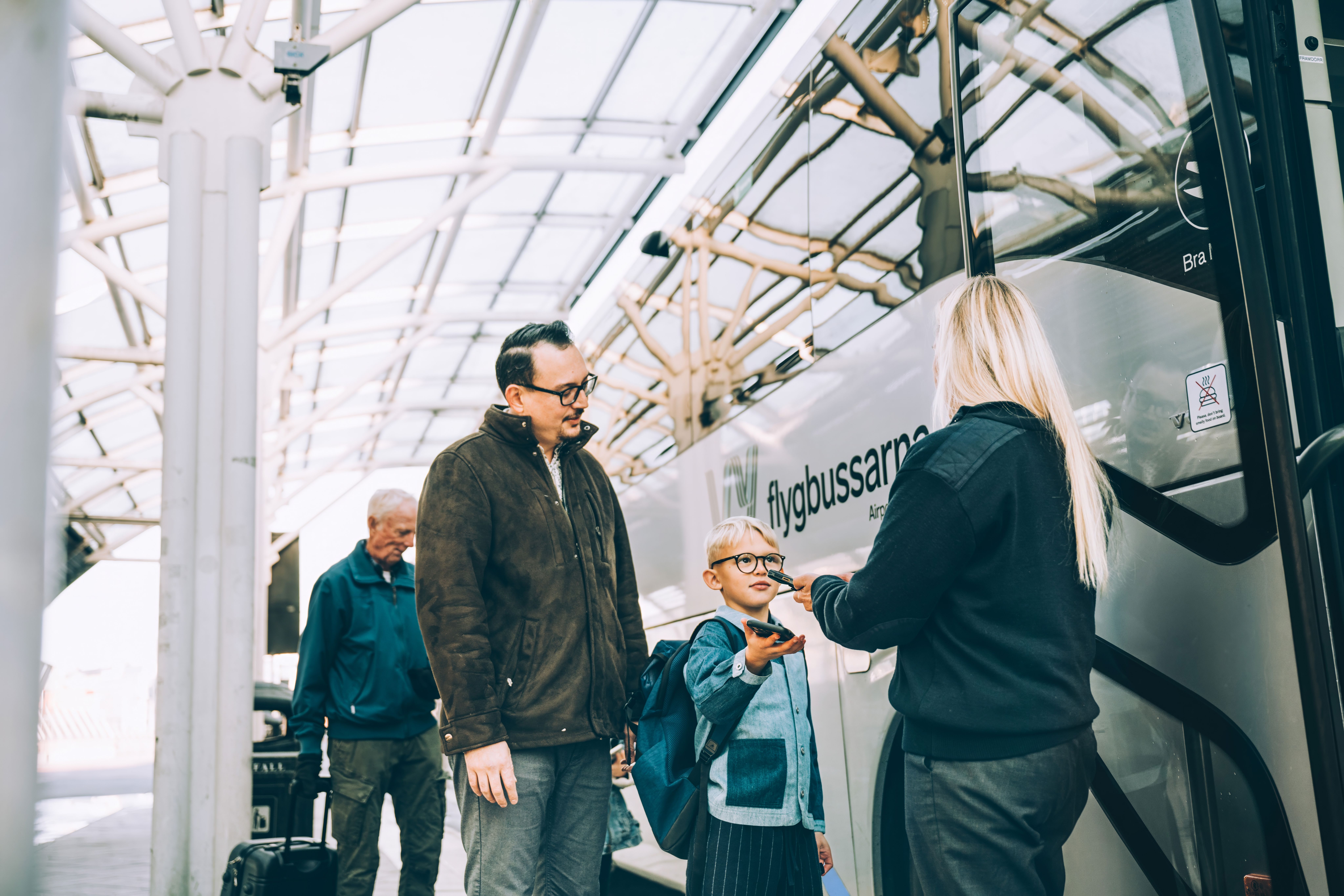 Barn och förälder scannar biljett till flygbuss
