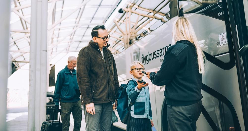 Barn och förälder scannar biljett till flygbuss