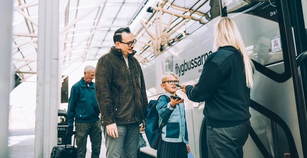 Child and father scan their ticket for the Airport Coach