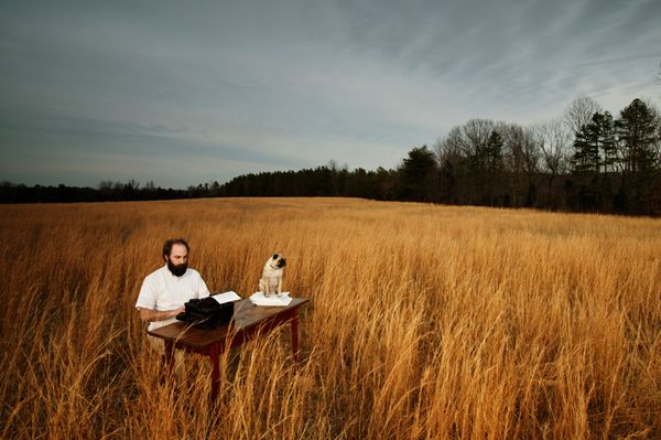 A man in a field typing