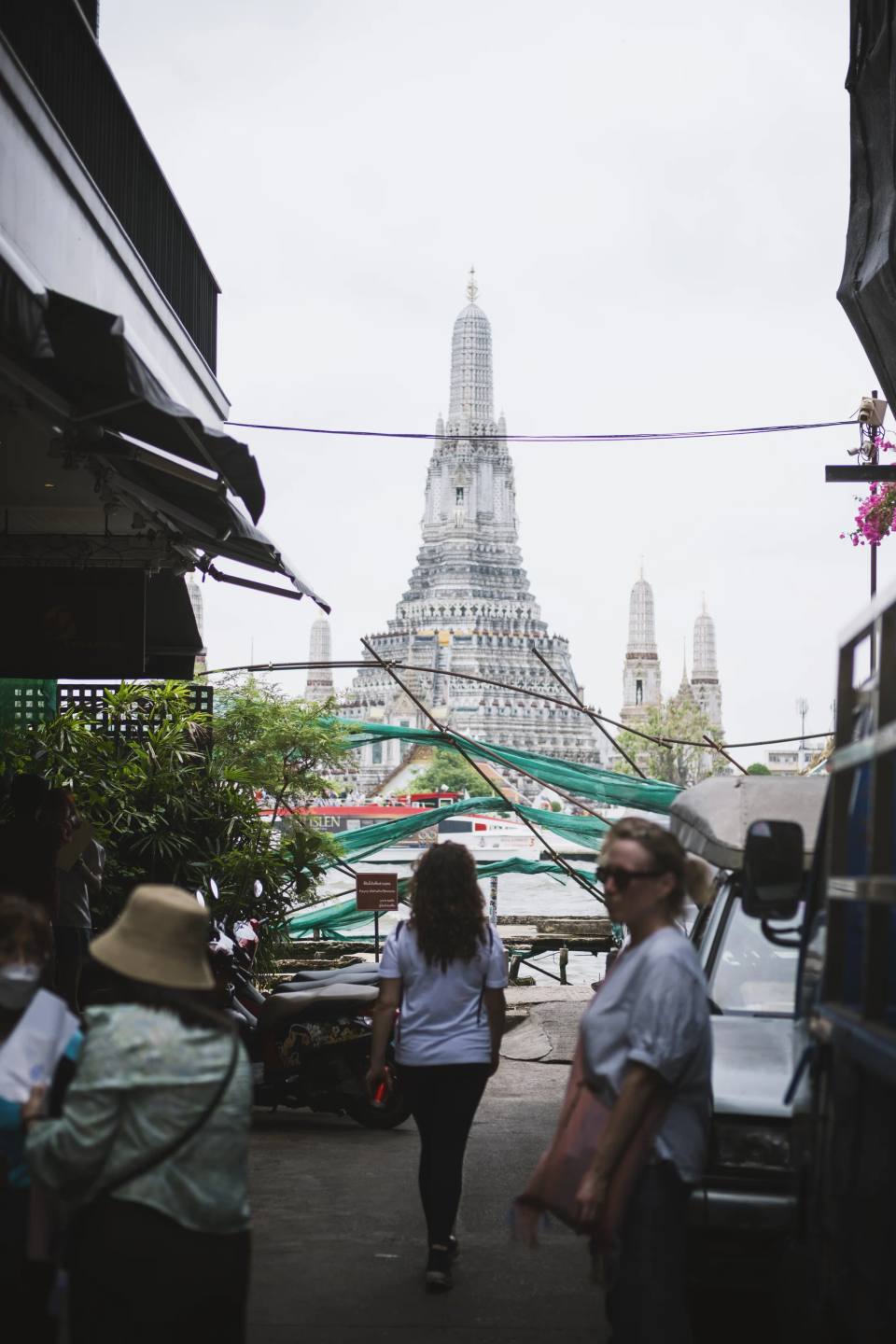 People walking towards a temple between market stalls.