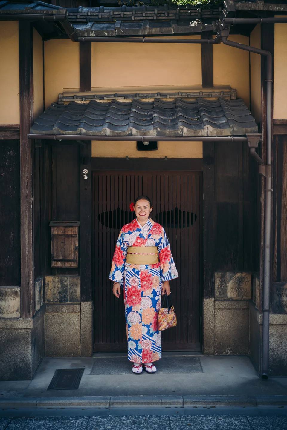 A person in a colourful kimono framed by a traditional doorway.