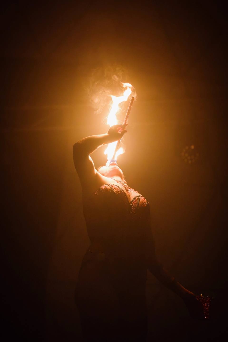 Female performer swallowing fire torch