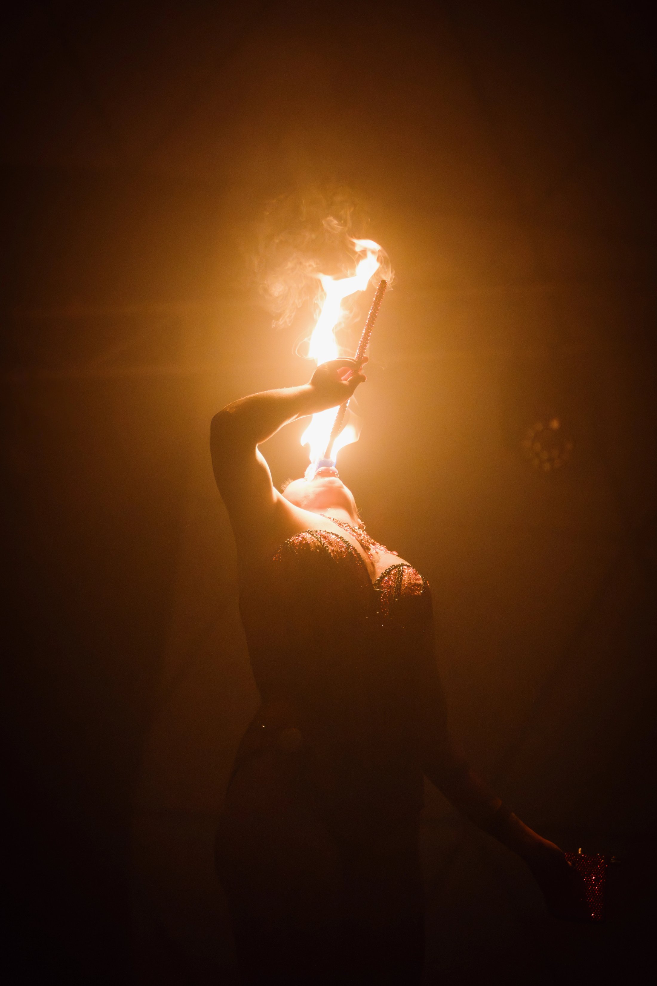 Female performer swallowing fire torch