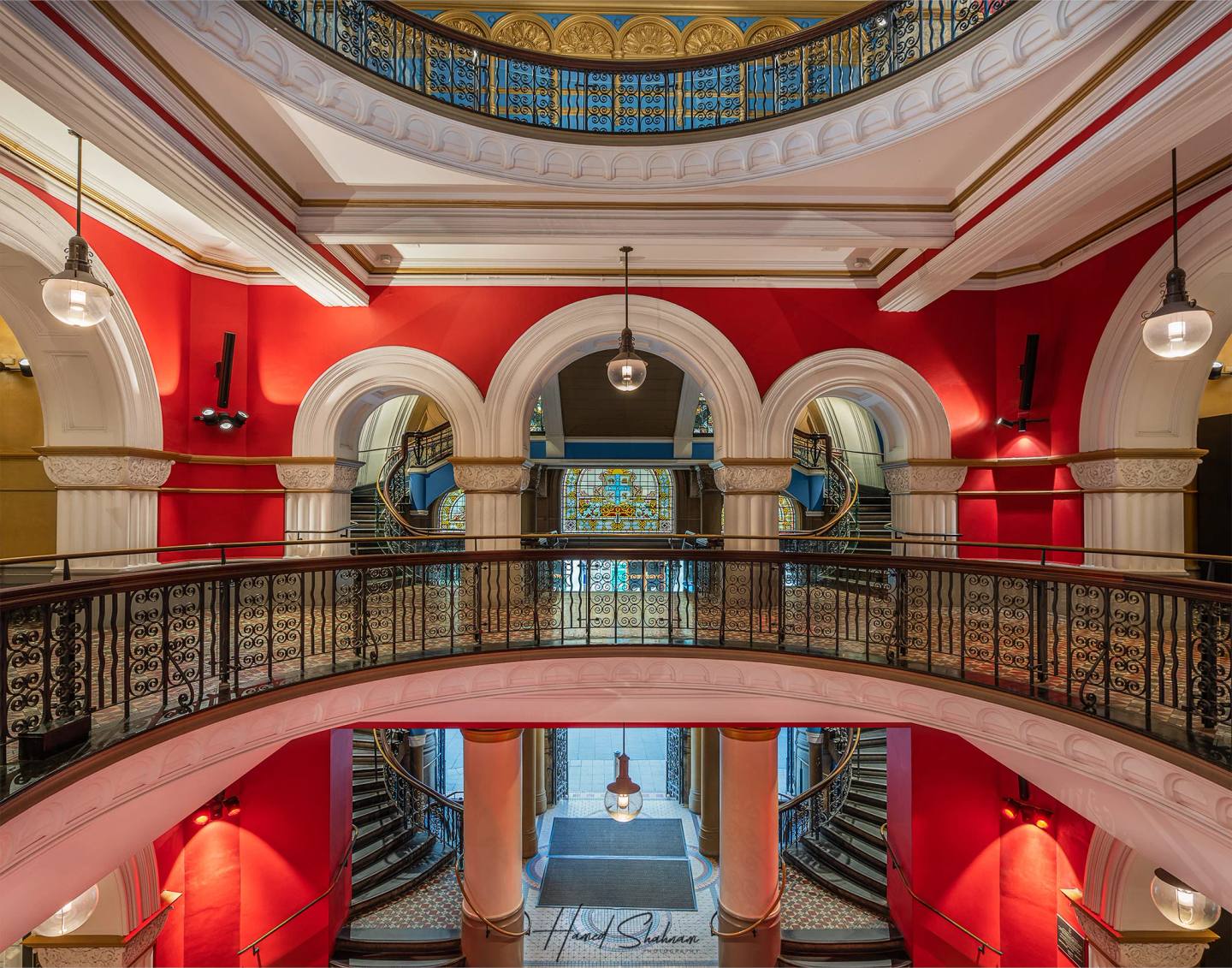 Red walls, arches and ornate railings inside the Queen Victoria Building.