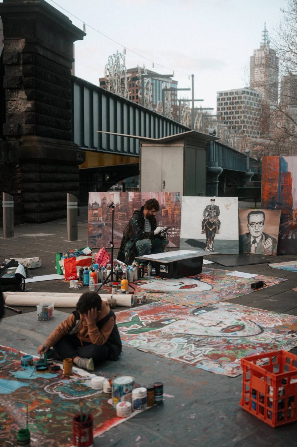 Melbourne street artist painting with city in backdrop