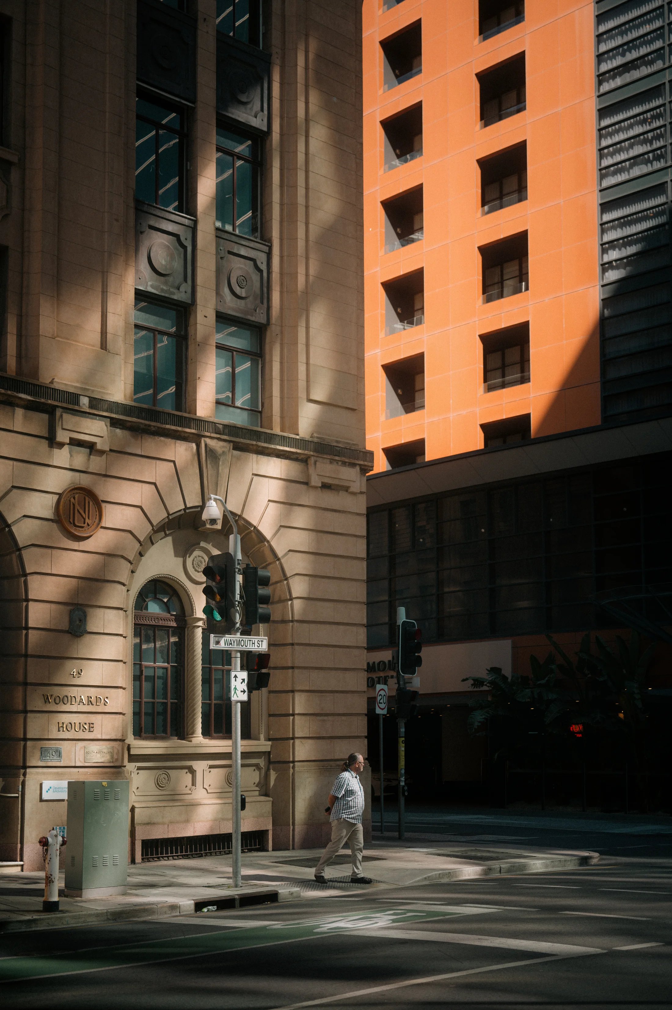 Warm orange architecture rising above an older stone facade.