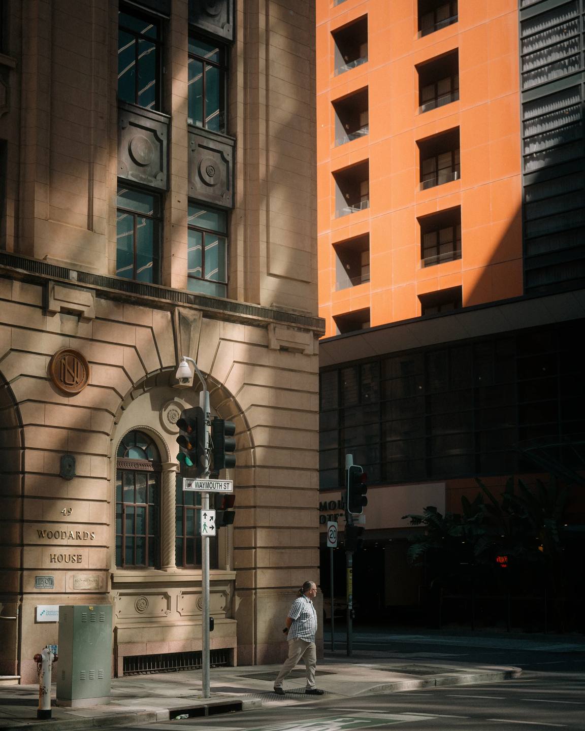 Warm orange architecture rising above an older stone facade.
