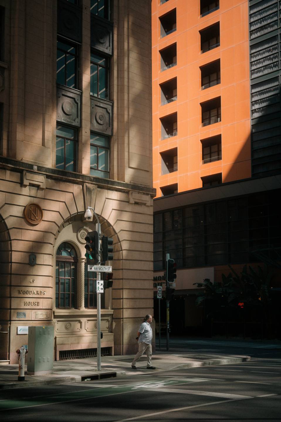 Warm orange architecture rising above an older stone facade.