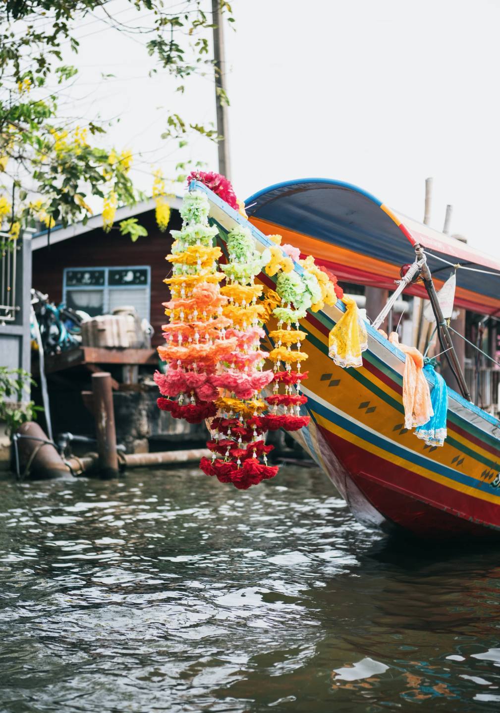 A decorated boat beside a busy waterside market.