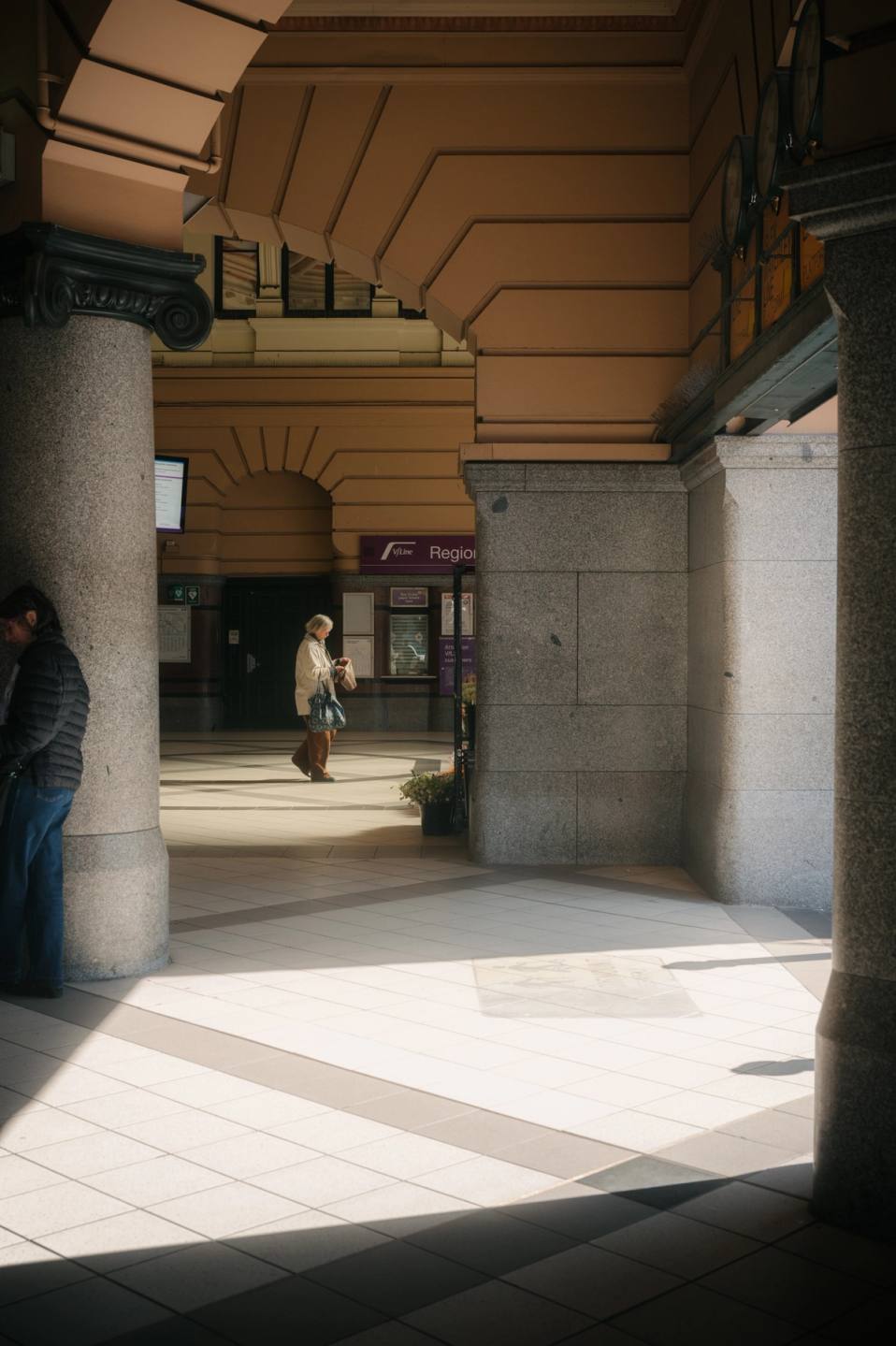 Lady walking through corridor illuminated by side light