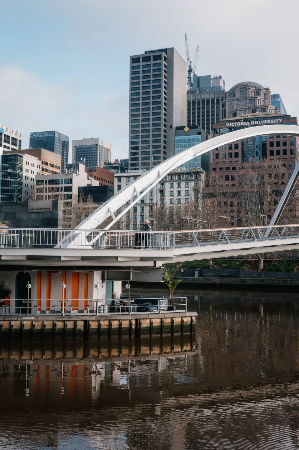 A white arched footbridge crossing the river.