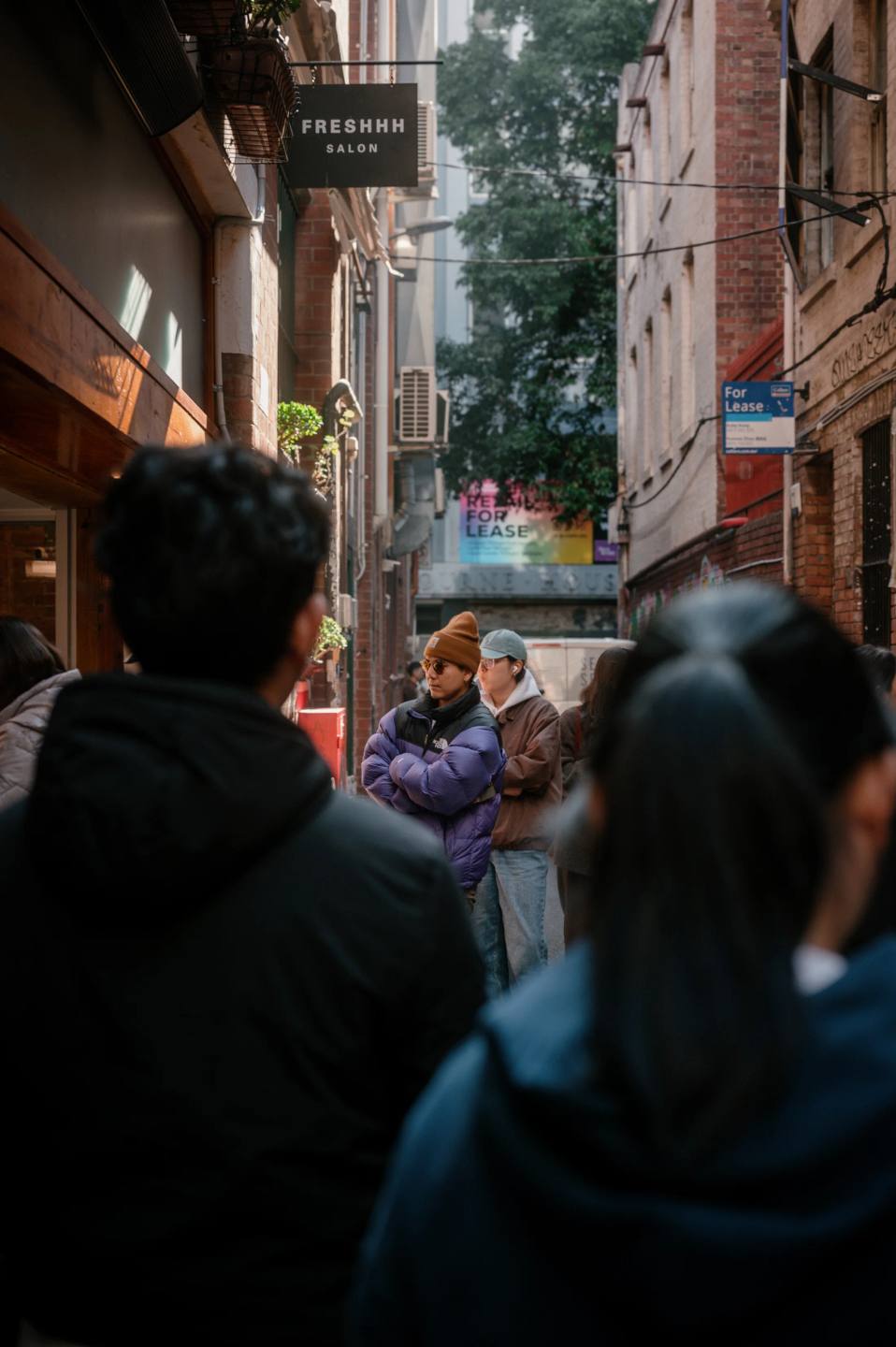 Pedestrians moving through a narrow city laneway.
