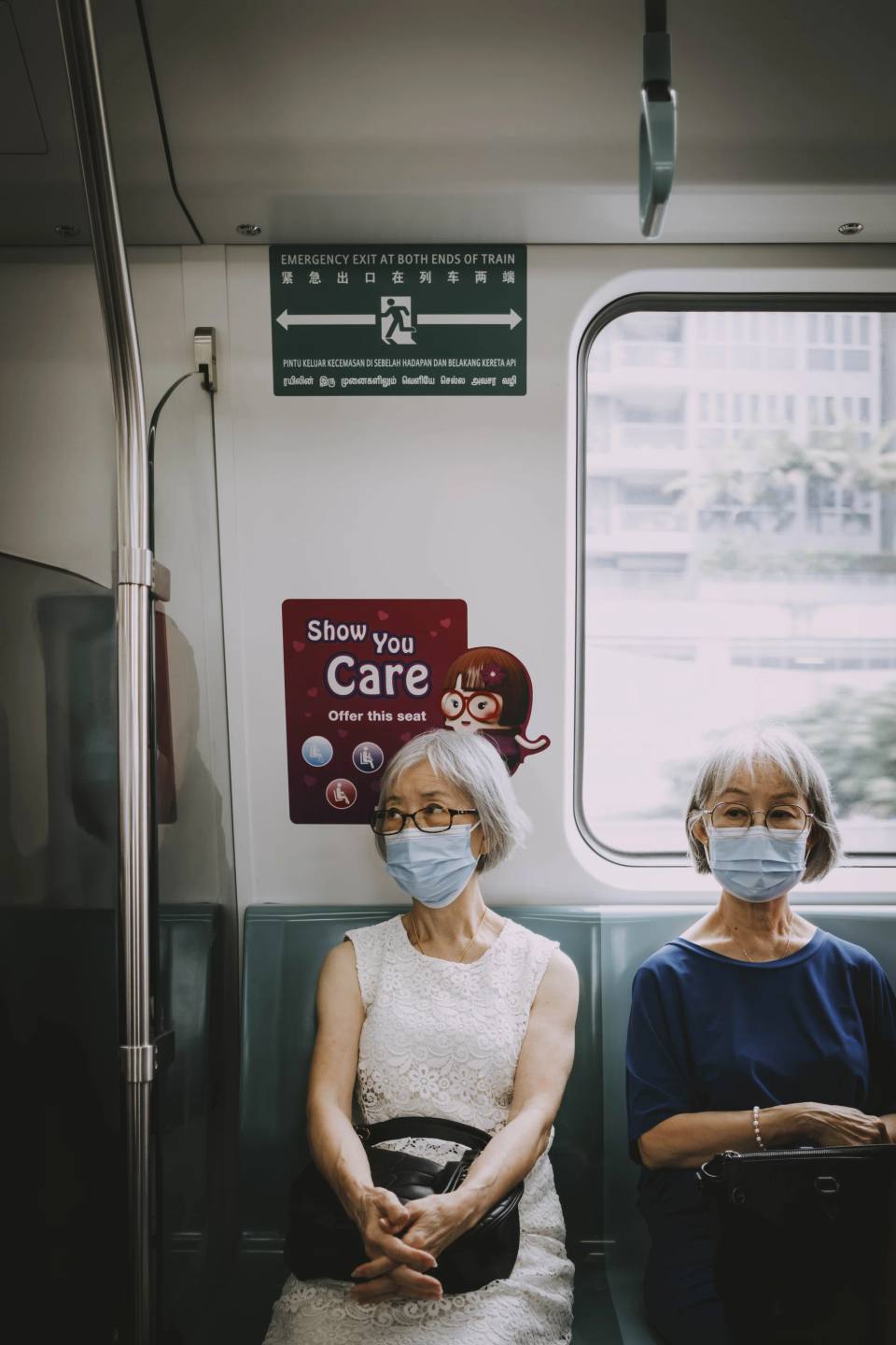 Two passengers seated inside a train carriage.
