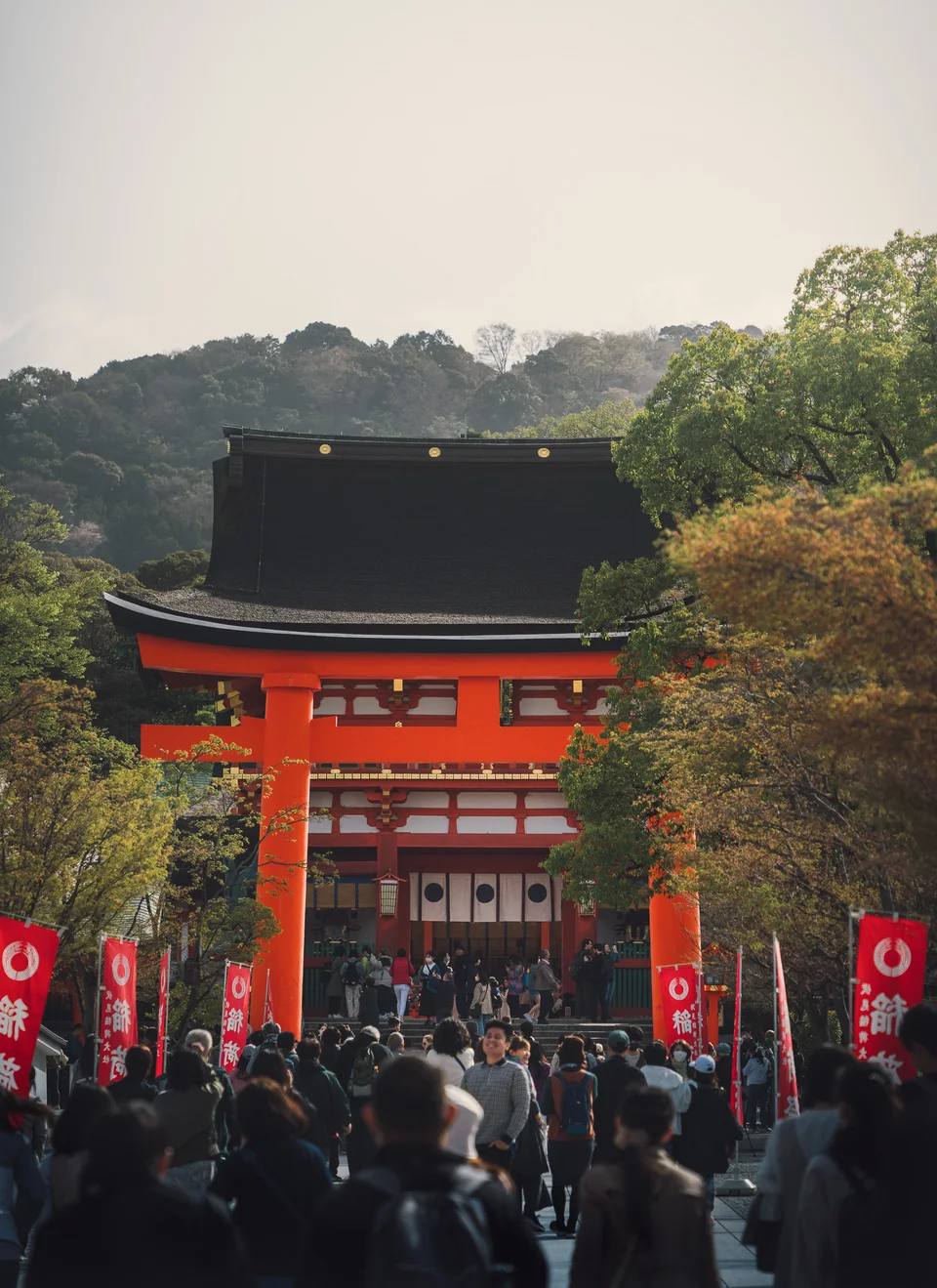 A crowd beneath a vermilion shrine gateway.