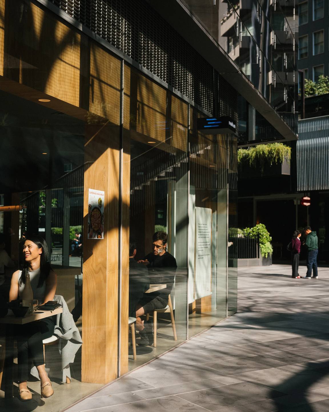 Warm sunlight and long shadows outside a city cafe.