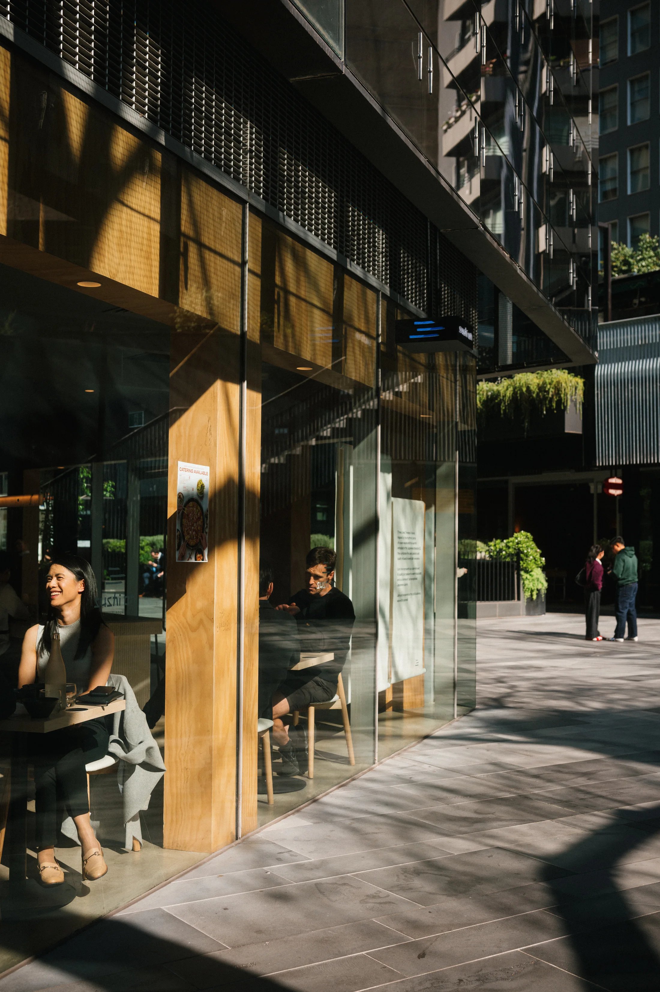 Warm sunlight and long shadows outside a city cafe.