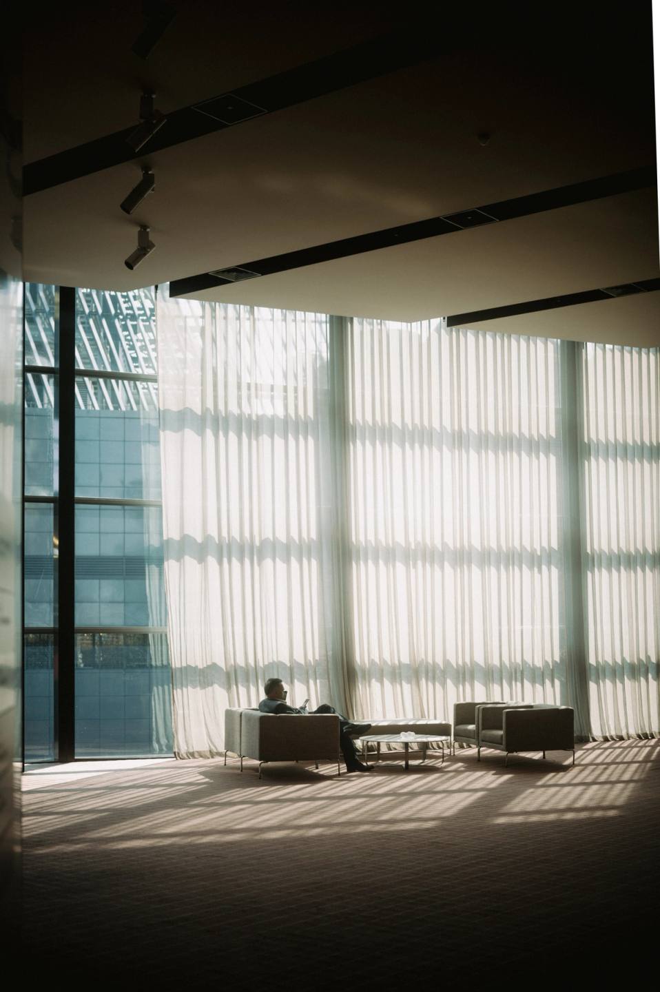 Man sitting in silhouette against window
