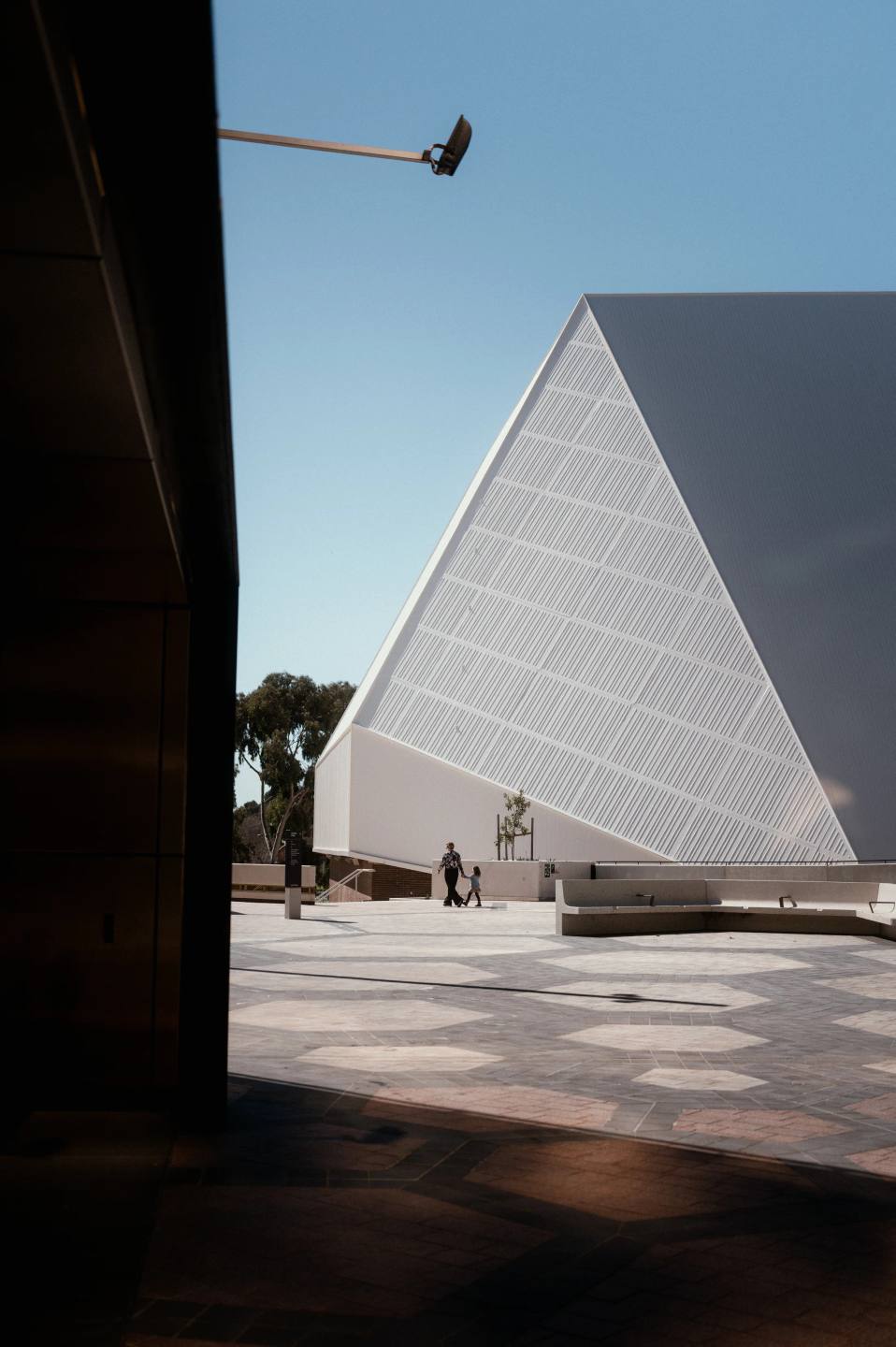 An angular white building framed by deep street shadows.